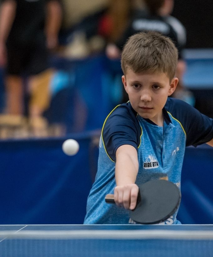 Ung bordtennisspiller i kamp ved et af bordene under Bordtennisfestival 2025 i Roskilde Kongres- og Idrætscenter.