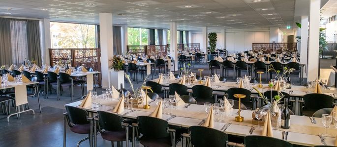 Restauranten i Roskilde Kongres- og Idrætscenter dækket op med lange borde til bespisning ved et større arrangement. 