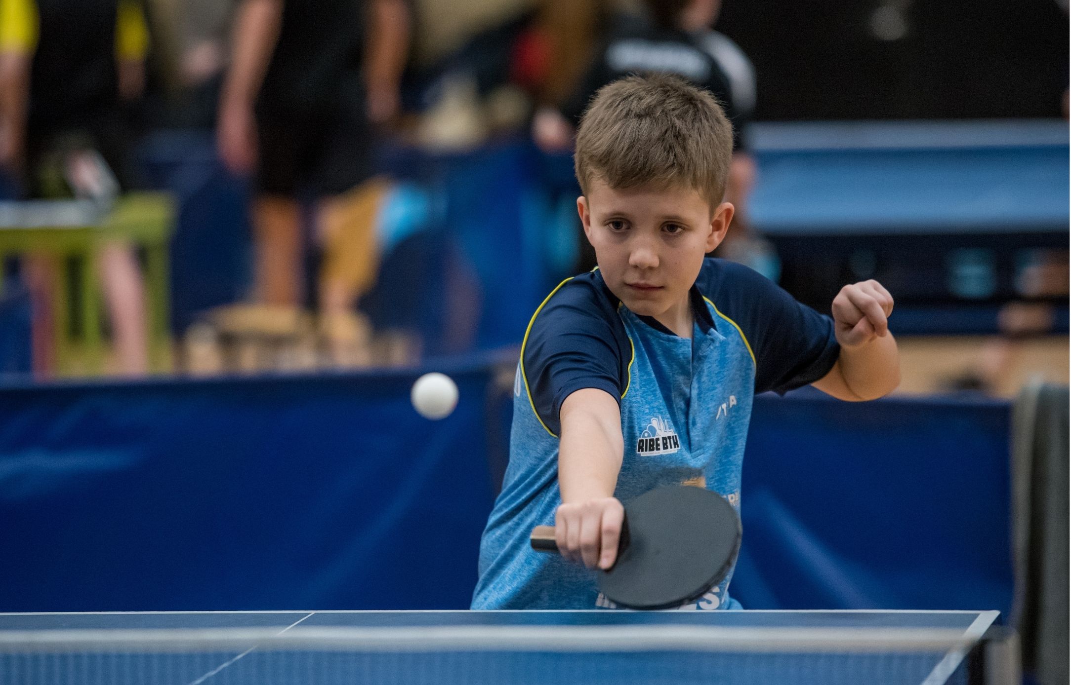 Ung bordtennisspiller i kamp ved et af bordene under Bordtennisfestival 2025 i Roskilde Kongres- og Idrætscenter.