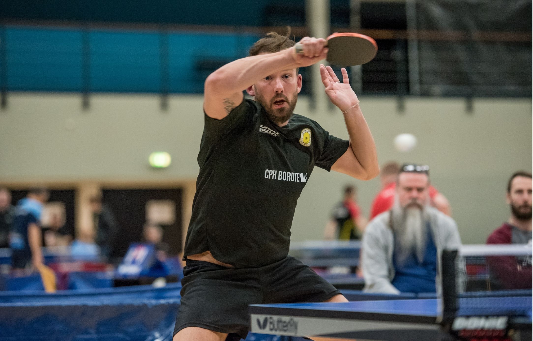 Bordtennisspiller i bevægelse under en kamp ved Bordtennisfestival 2025 i Roskilde Kongres- og Idrætscenter.