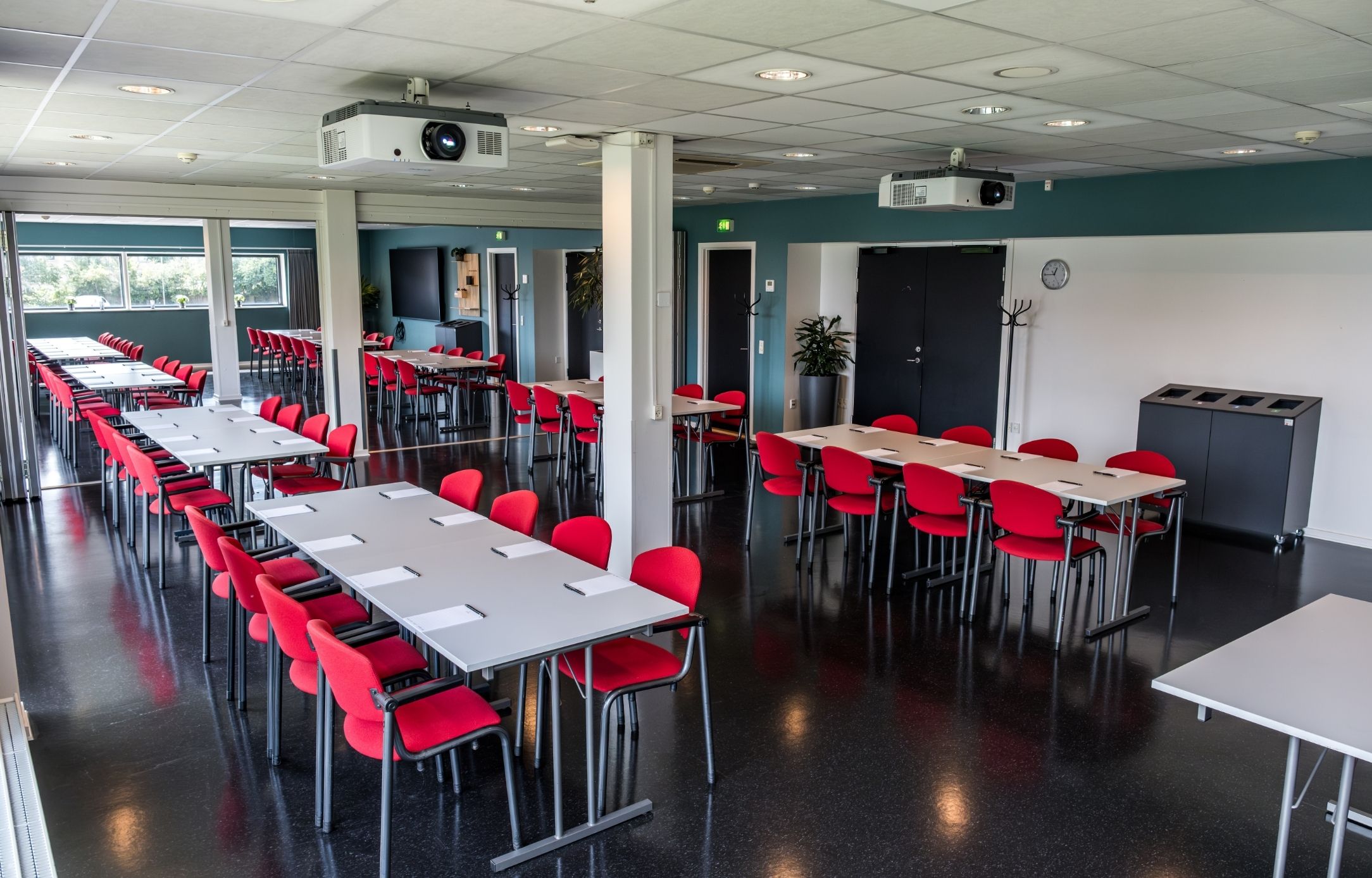 Maglekilde indrettet med borde og røde stole i en fleksibel opstilling til møder, workshops og undervisning.
