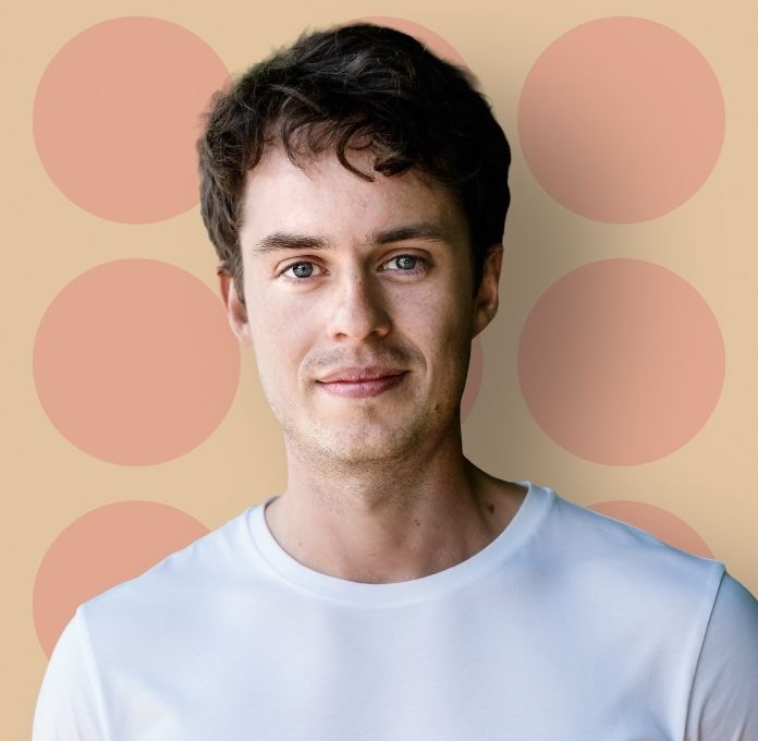 Nicklas Brendborg på beige baggrund med røde og lyserøde cirkler samt teksten ”De elleve – foredrag med Nicklas Brendborg”.