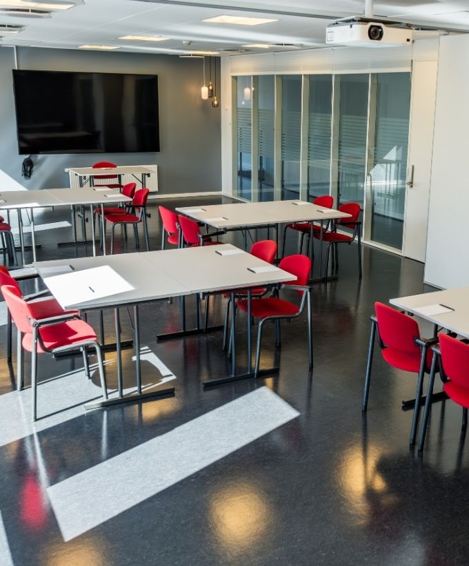 Roar indrettet med borde i mindre grupper samt storskærm til møder, kurser og workshops.