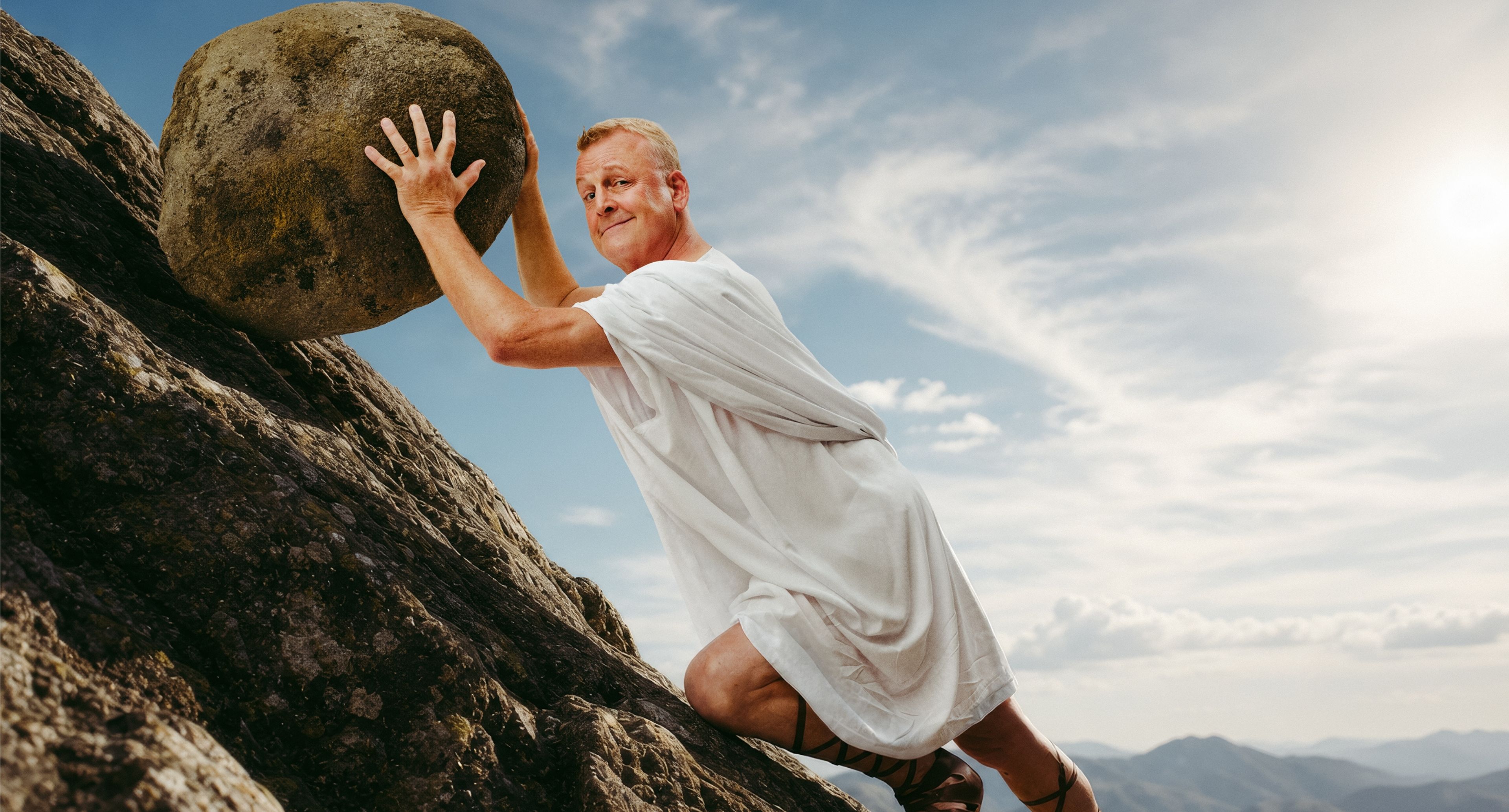 Jan Gintberg står ved siden af en stor sten med hånden mod stenen.