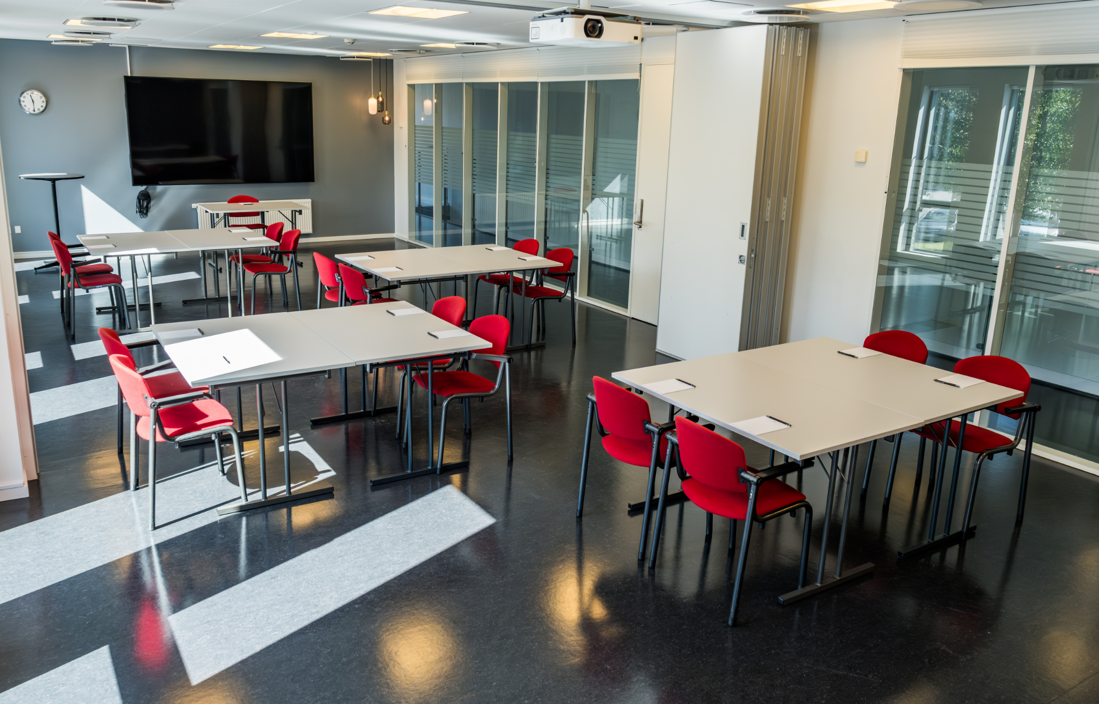 Roar indrettet med borde i mindre grupper samt storskærm til møder, kurser og workshops.