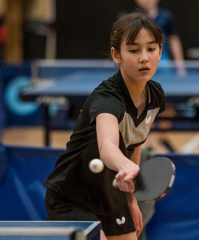 Ung bordtennisspiller returnerer bolden under Bordtennisfestival 2025 i Roskilde Kongres- og Idrætscenter.