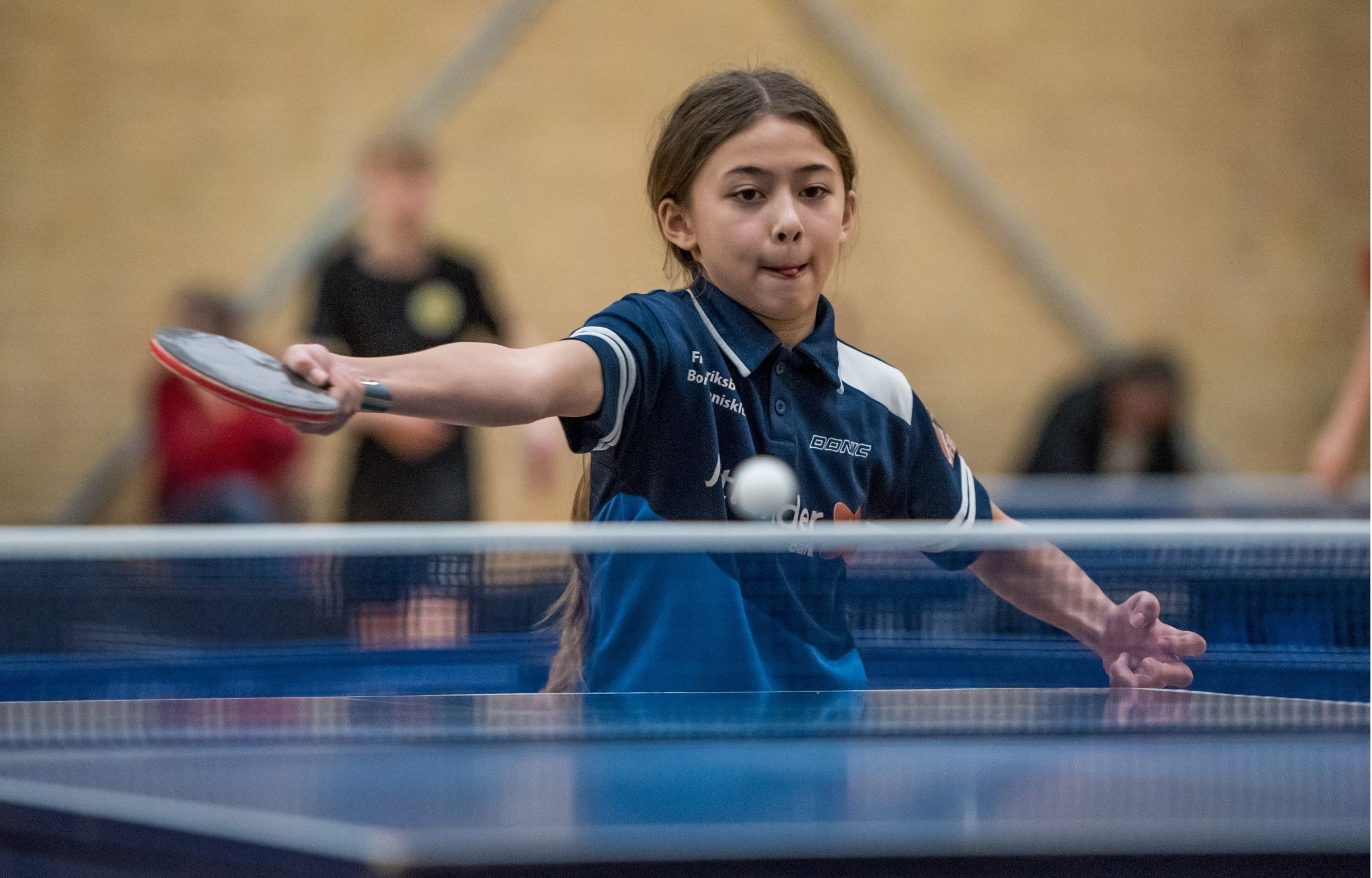 Ung bordtennisspiller returnerer bolden under Bordtennisfestival 2025 i Roskilde Kongres- og Idrætscenter.