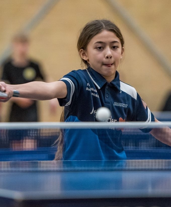 Ung bordtennisspiller returnerer bolden under Bordtennisfestival 2025 i Roskilde Kongres- og Idrætscenter.