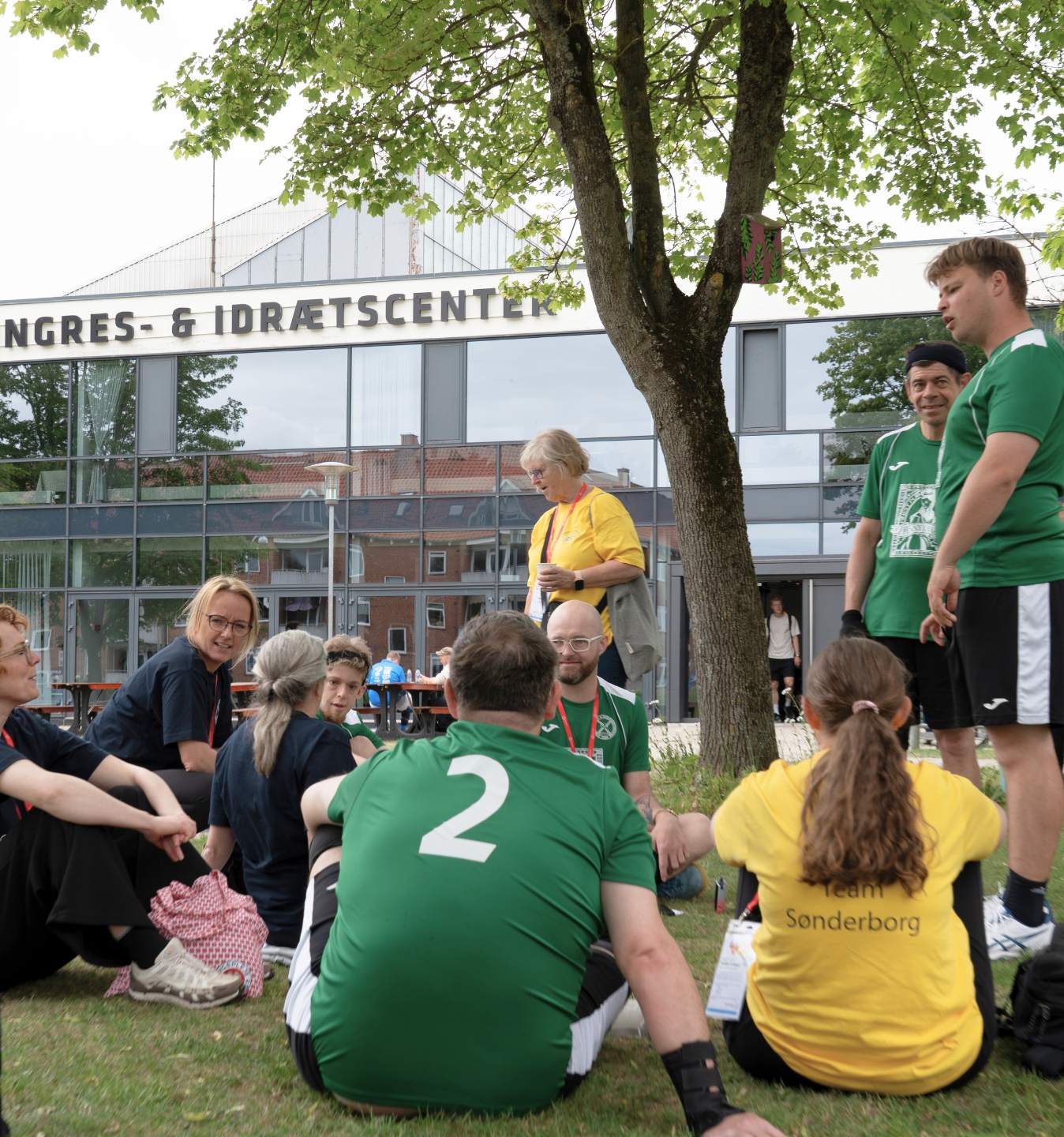Deltagere og frivillige holder pause uden for Roskilde Kongres- og Idrætscenter