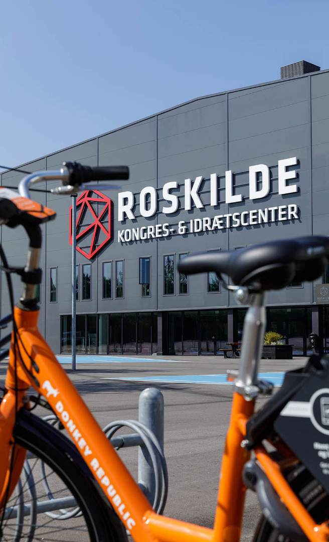 Roskilde Kongres- og Idrætscenter set udefra med bycykler i forgrunden