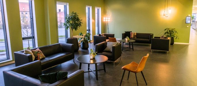 Kilden i Roskilde Kongres- og Idrætscenter indrettet med sofaer, lænestole, grønne planter og små borde til pauser og uformelt ophold. 