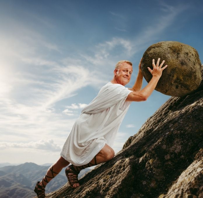 Jan Gintberg står ved siden af en stor sten med hånden mod stenen.