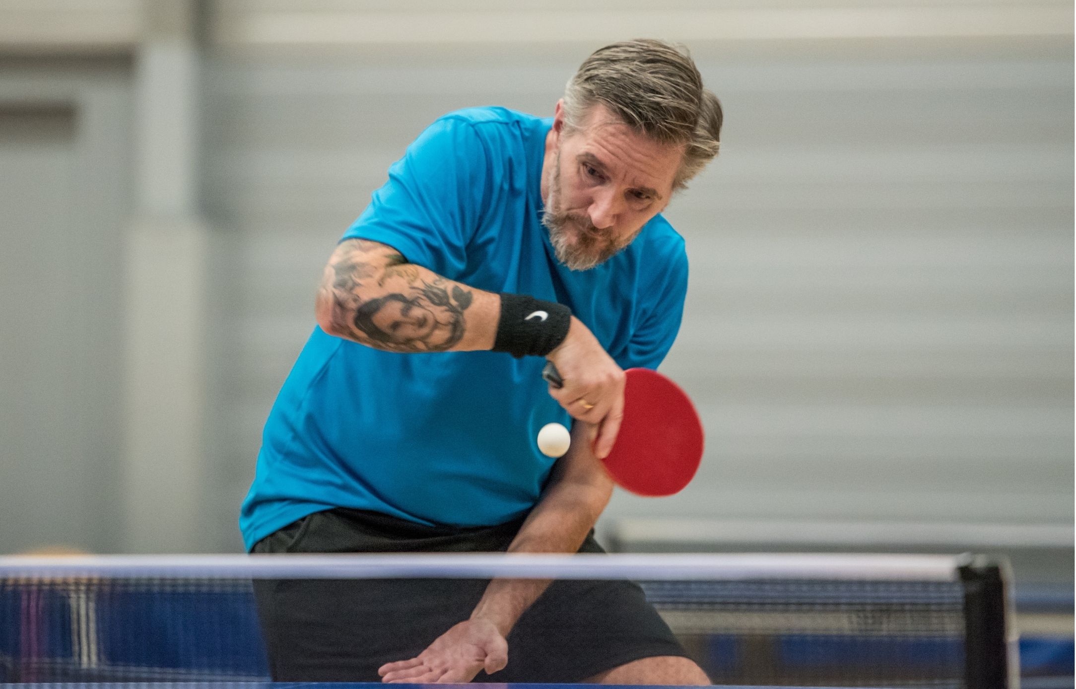 Bordtennisspiller rammer bolden tæt ved nettet under Bordtennisfestival 2025 i Roskilde Kongres- og Idrætscenter.